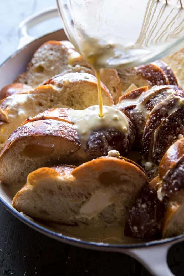 action shot of pouring egg batter over Baked Blackberry Ricotta French Toast