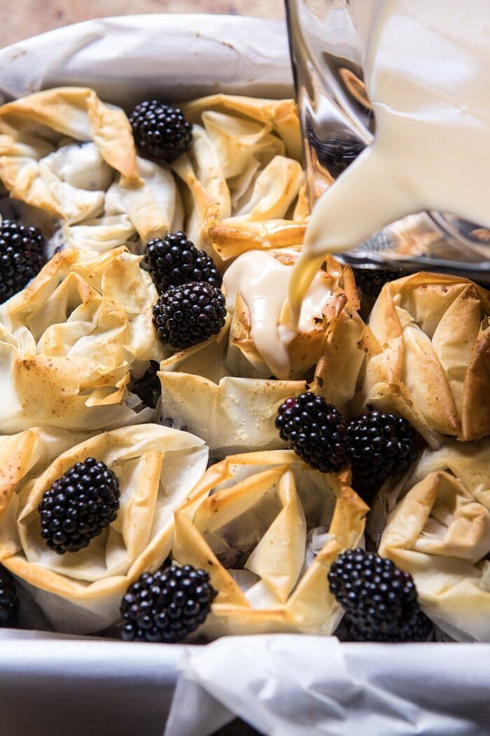 pouring the custard over the phyllo rolls for Blackberry Ruffled Milk Pie 