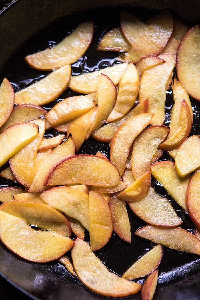 overhead photo of sliced peaches in browned butter in skillet