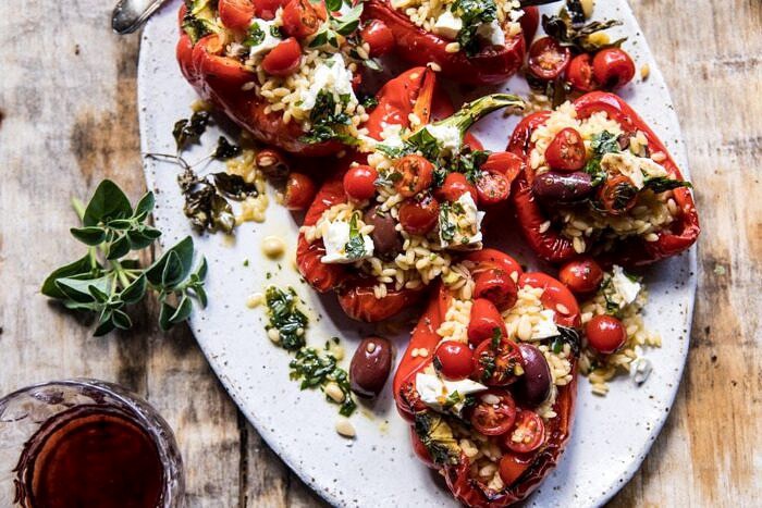 overhead horizontal photo of Greek Orzo Stuffed Red Peppers with Lemony Basil Tomatoes 