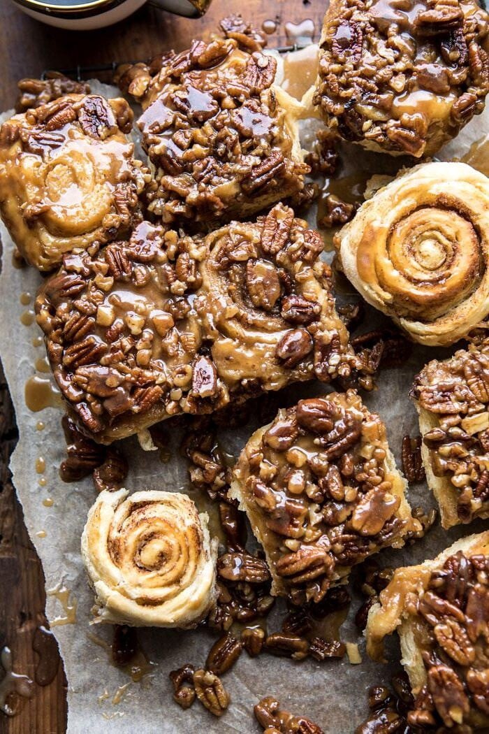 overhead photo of Extra Sticky Maple Pecan Sticky Buns with 2 buns flipped upside to show their swirl