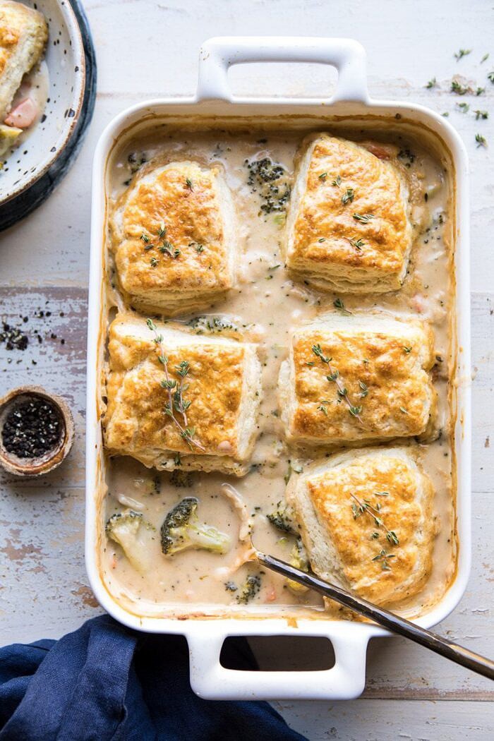 overhead photo of Homemade Broccoli Cheddar Cobbler with serving spoon in casserole dish