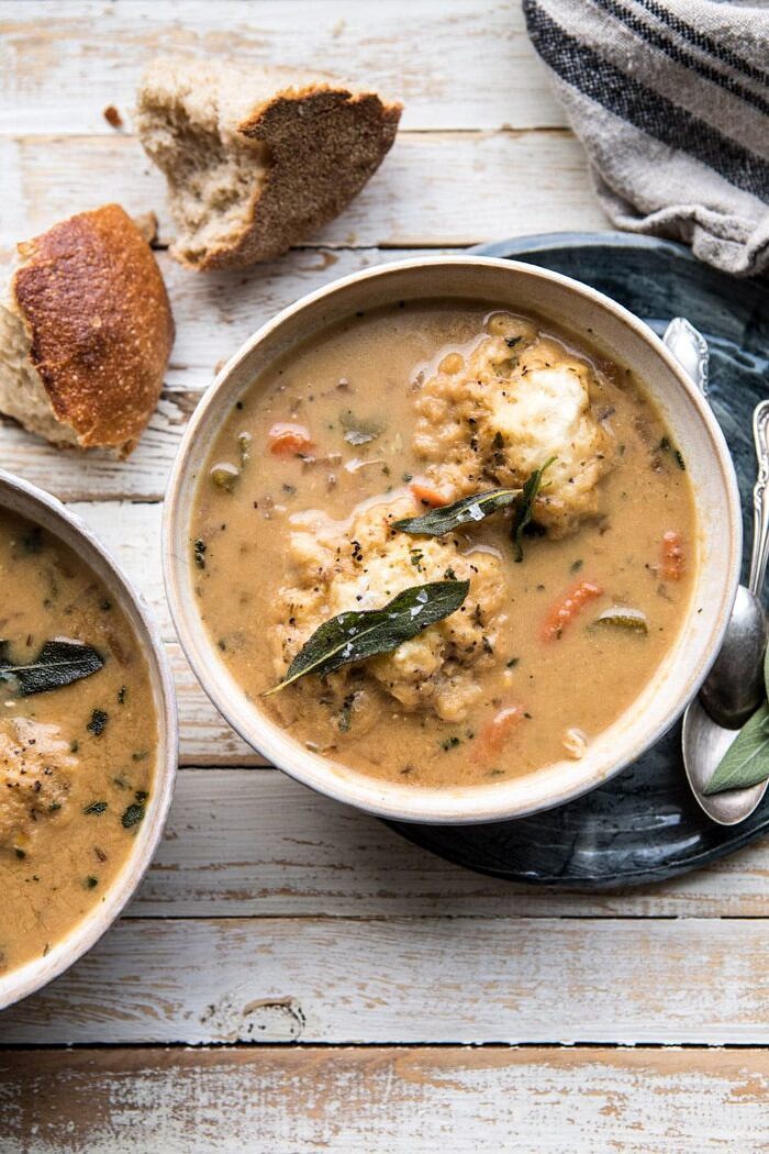 overhead photo of One Pot Chicken and Sage Dumplings with bread in table