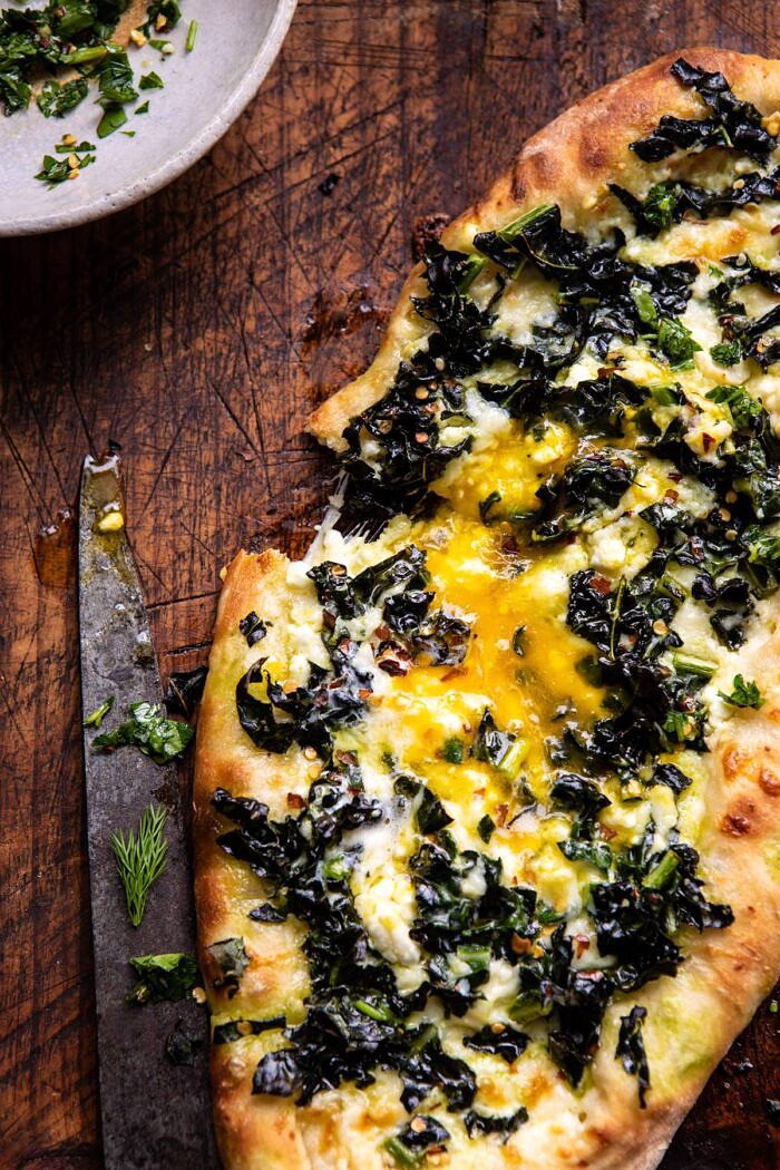 overhead close up photo Khachapuri (Georgian Cheese Bread) with Kale and Herb Sauce 