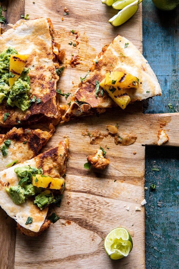 overhead photo of Cauliflower Al Pastor Quesadillas with Lime Smashed Avocado half eaten