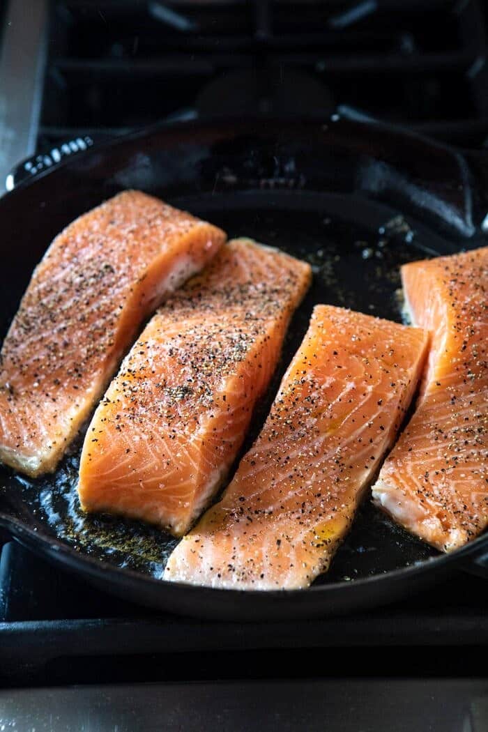 raw salmon cooking in skillet 
