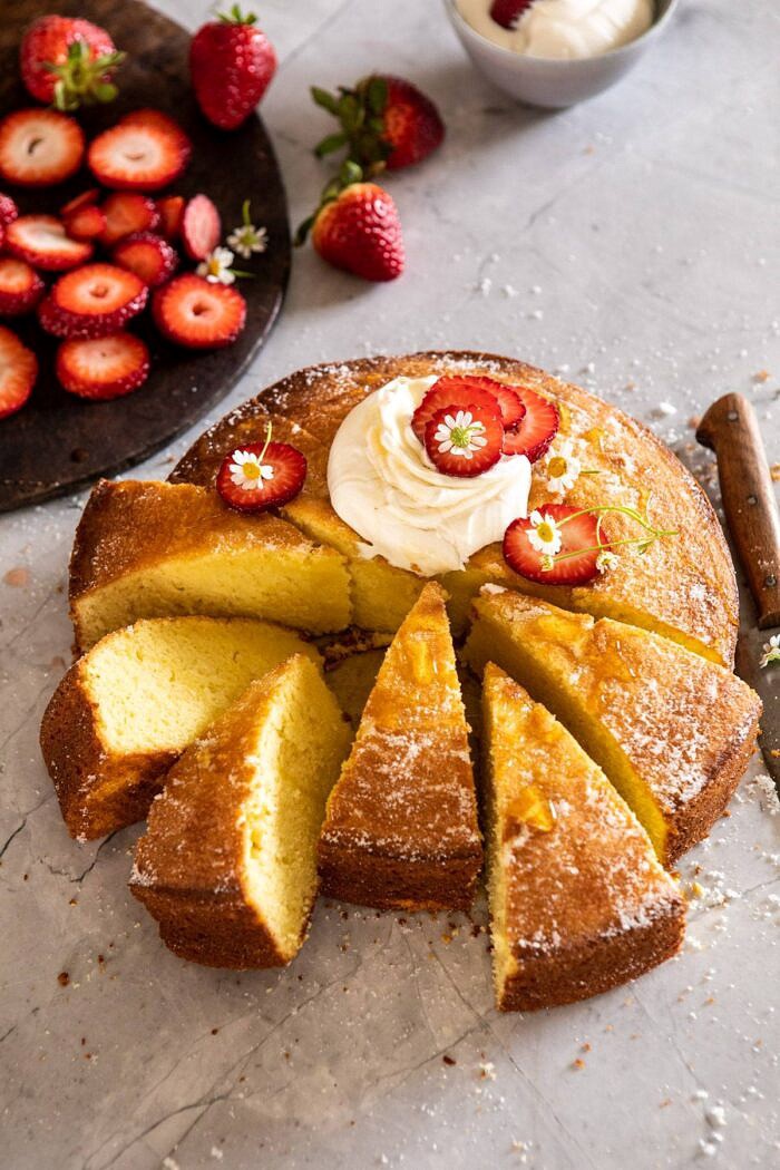 side angled photo of Strawberry Chamomile Olive Oil Cake with Honeyed Ricotta with 6 slices cut out
