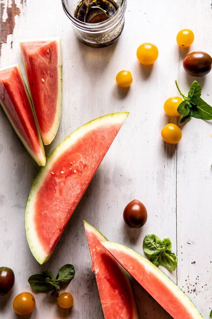 Watermelon and tomatoes on cutting board 