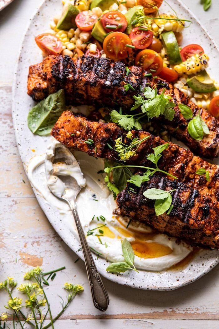 Lemon Parmesan Salmon with Corn, Tomato, and Avocado Salad with serving of salmon removed from platter