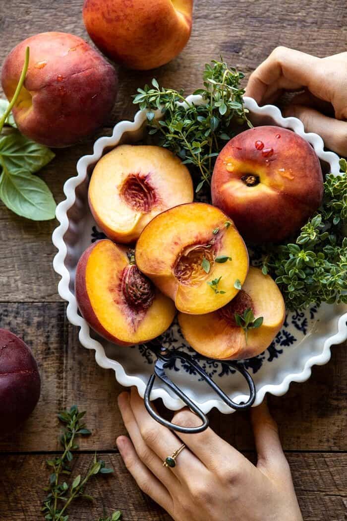 overhead photo of peaches in bowl with hands on bowl 