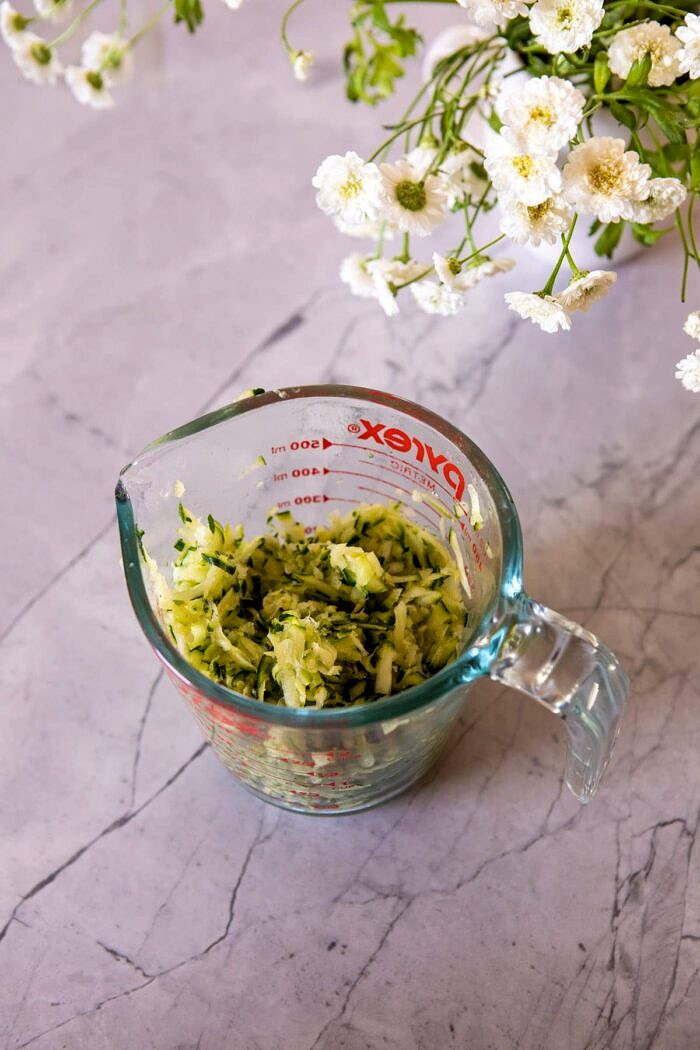 shredded zucchini in measuring cup