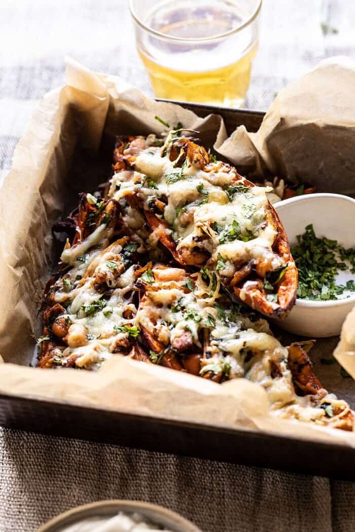 side angled photo of Healthy Chipotle Chicken Sweet Potato Skins with beer in background