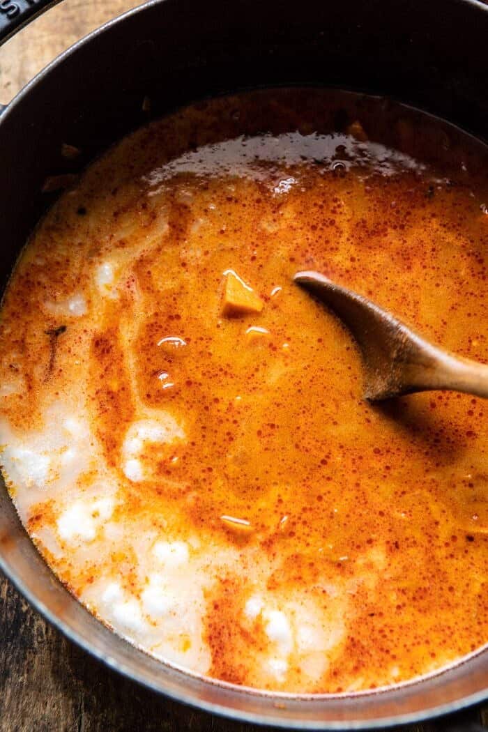 overhead photo of Sweet Potato Lentil Curry in pot after adding coconut milk 