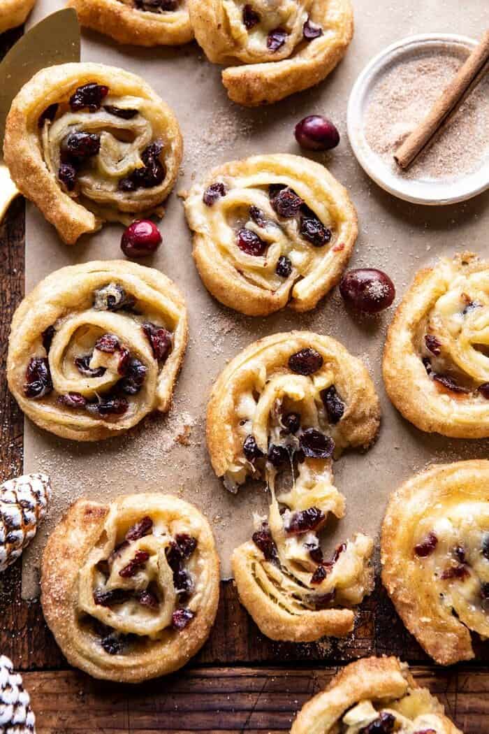 overhead photo of 5 Ingredient Cranberry Brie Cinnamon Puff Pastry Swirls with cheese being pulled out of swirl 