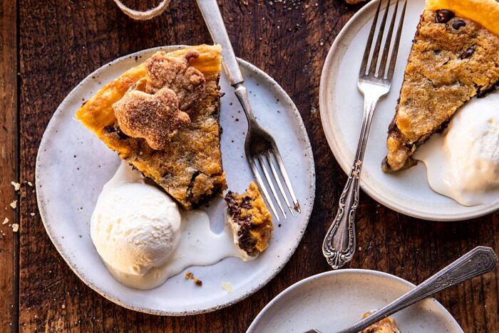horizontal photo of Gooey Chocolate Chip Cookie Pumpkin Pie slices with ice cream on plates