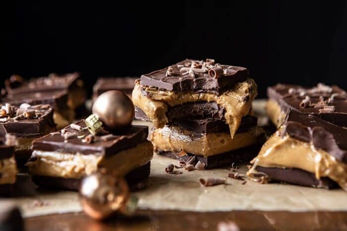 horizontal photo of 5 Ingredient Triple Decker Chocolate Peanut Butter Bars with large bite taken out of bar