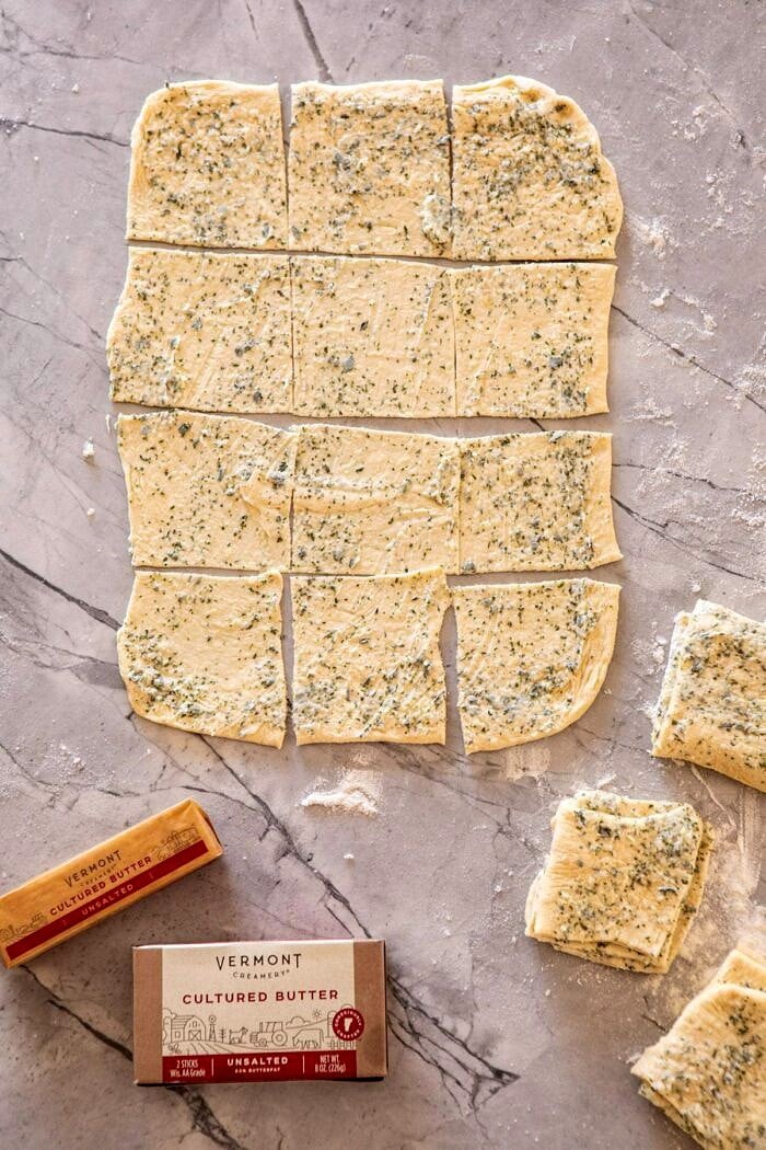 overhead photo of Pull-Apart Garlic Butter Bread dough while layering in the garlic butter 