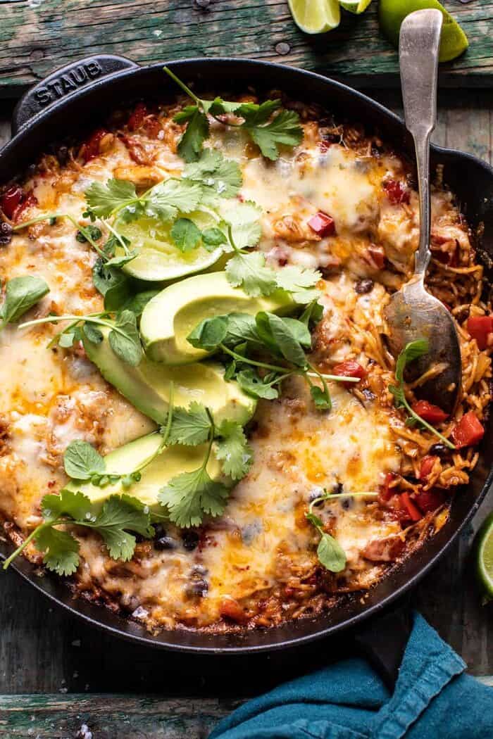 overhead close up photo of One Skillet Cheesy Cuban Chicken Rice Bake with spoon in skillet