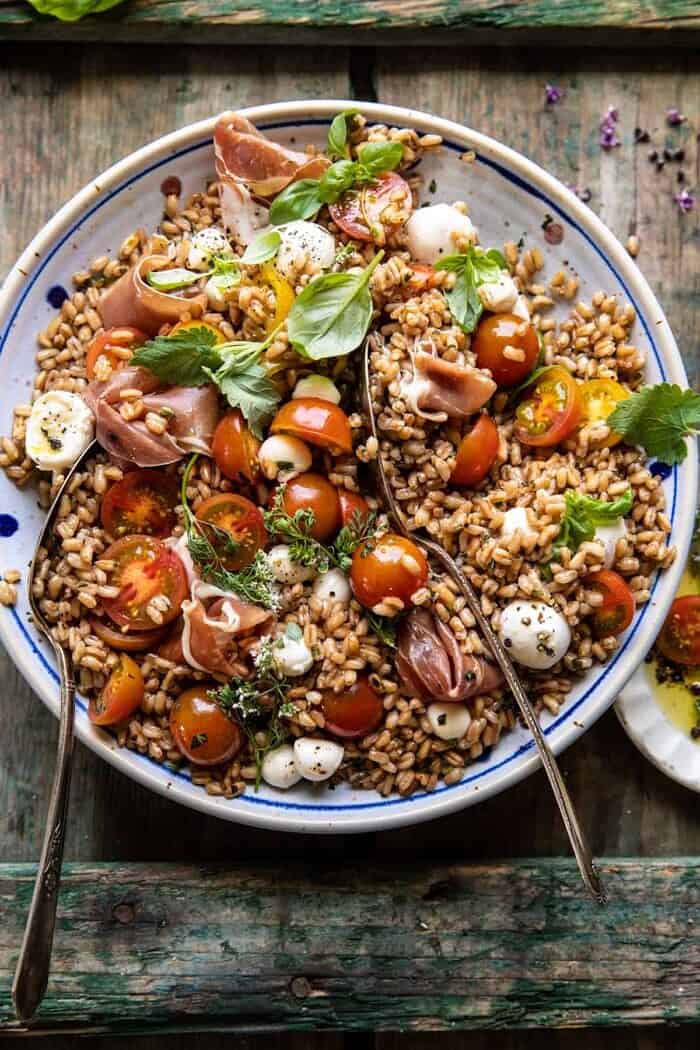 overhead photo of Caprese Prosciutto Farro Salad with spoons in salad bowl 