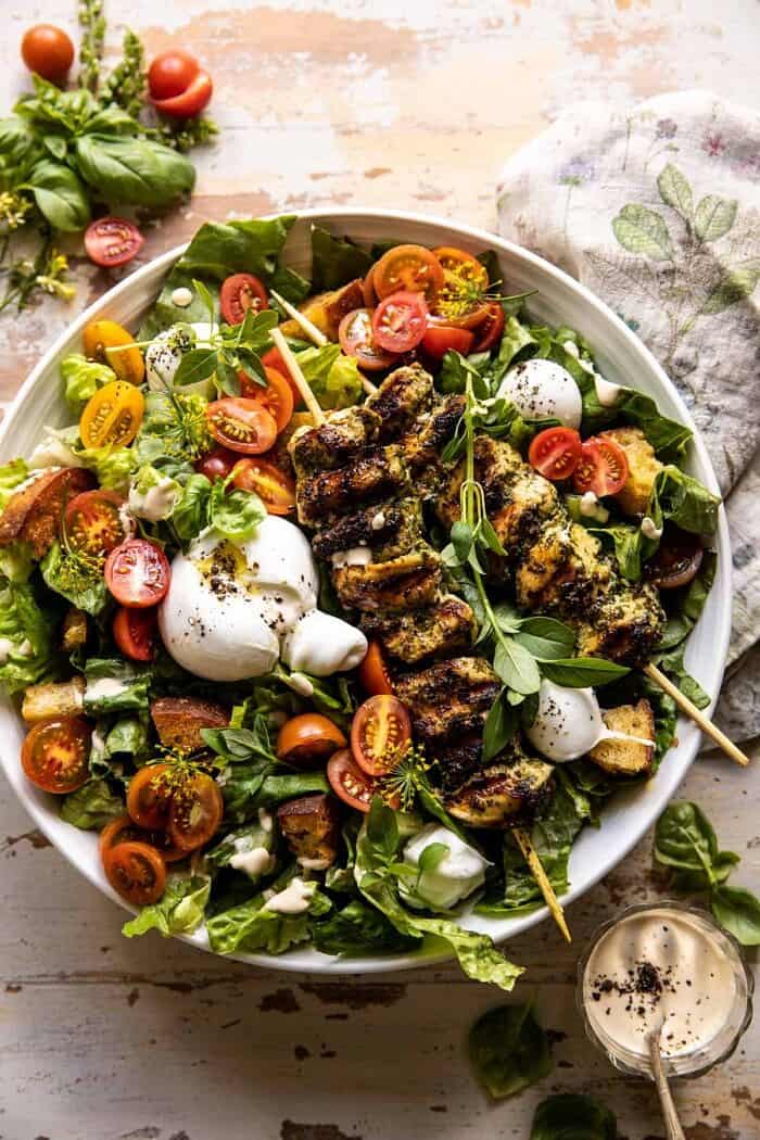 overhead photo of Pesto Chicken Caesar Salad with Tomatoes and Burrata