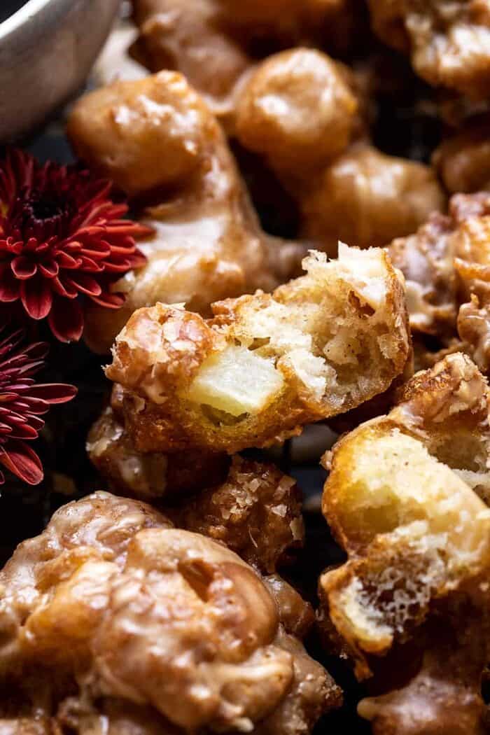side angled photo of Cinnamon Spiced Apple Fritters with Vanilla Coffee Glaze broken in half
