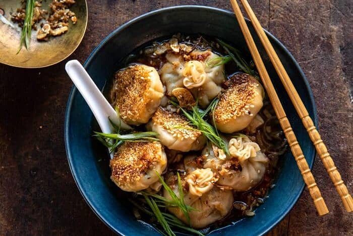 overhead horizontal photo of Sesame Chicken Dumplings in Spicy Broth with Garlic Crisps