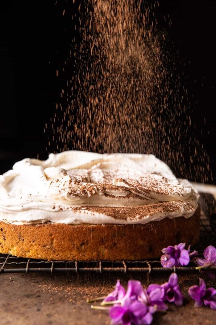 process photo of Vanilla Tiramisu Cake being dusted with cocoa