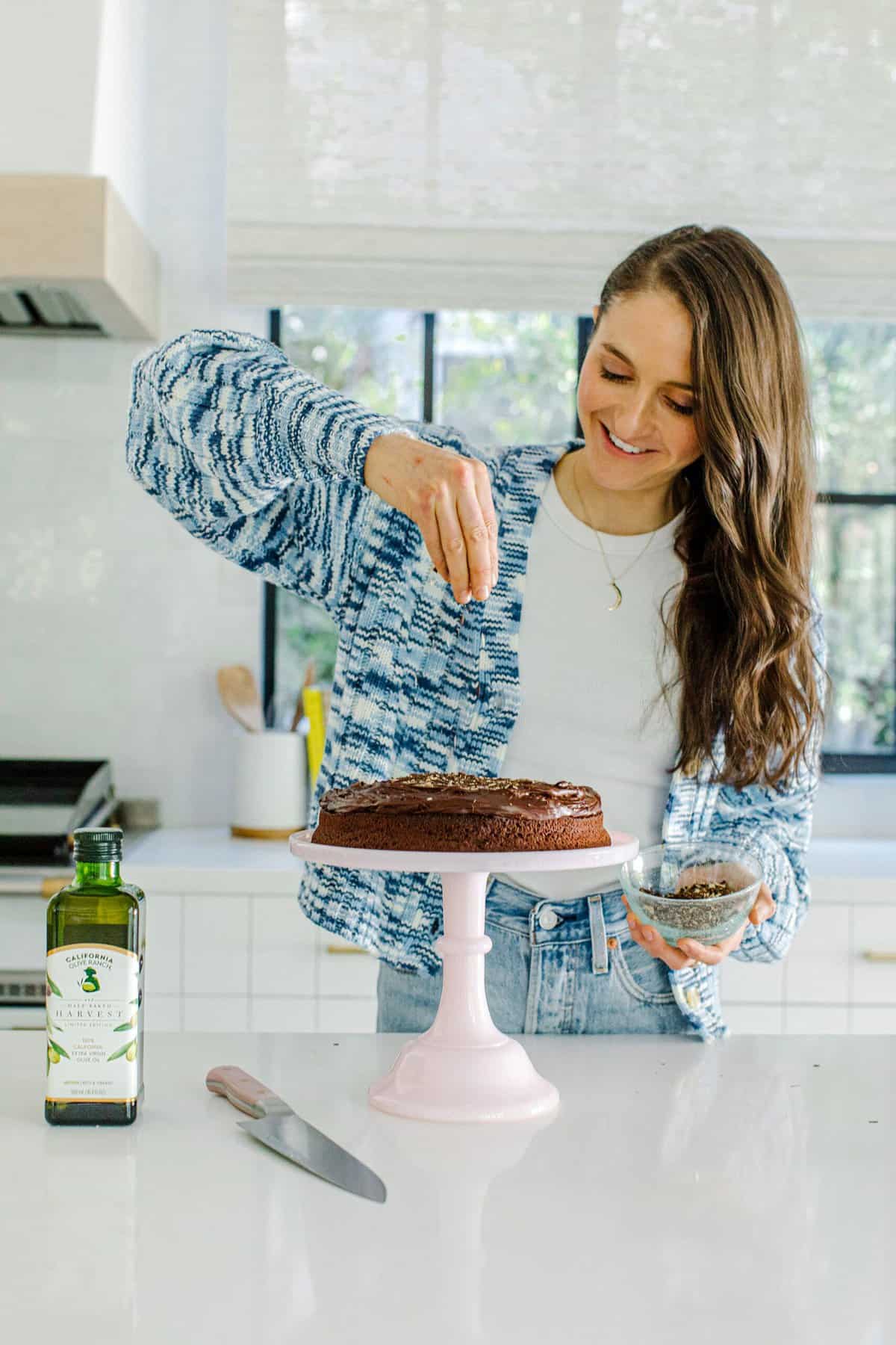 tieghan sprinkling chocolate on cake 