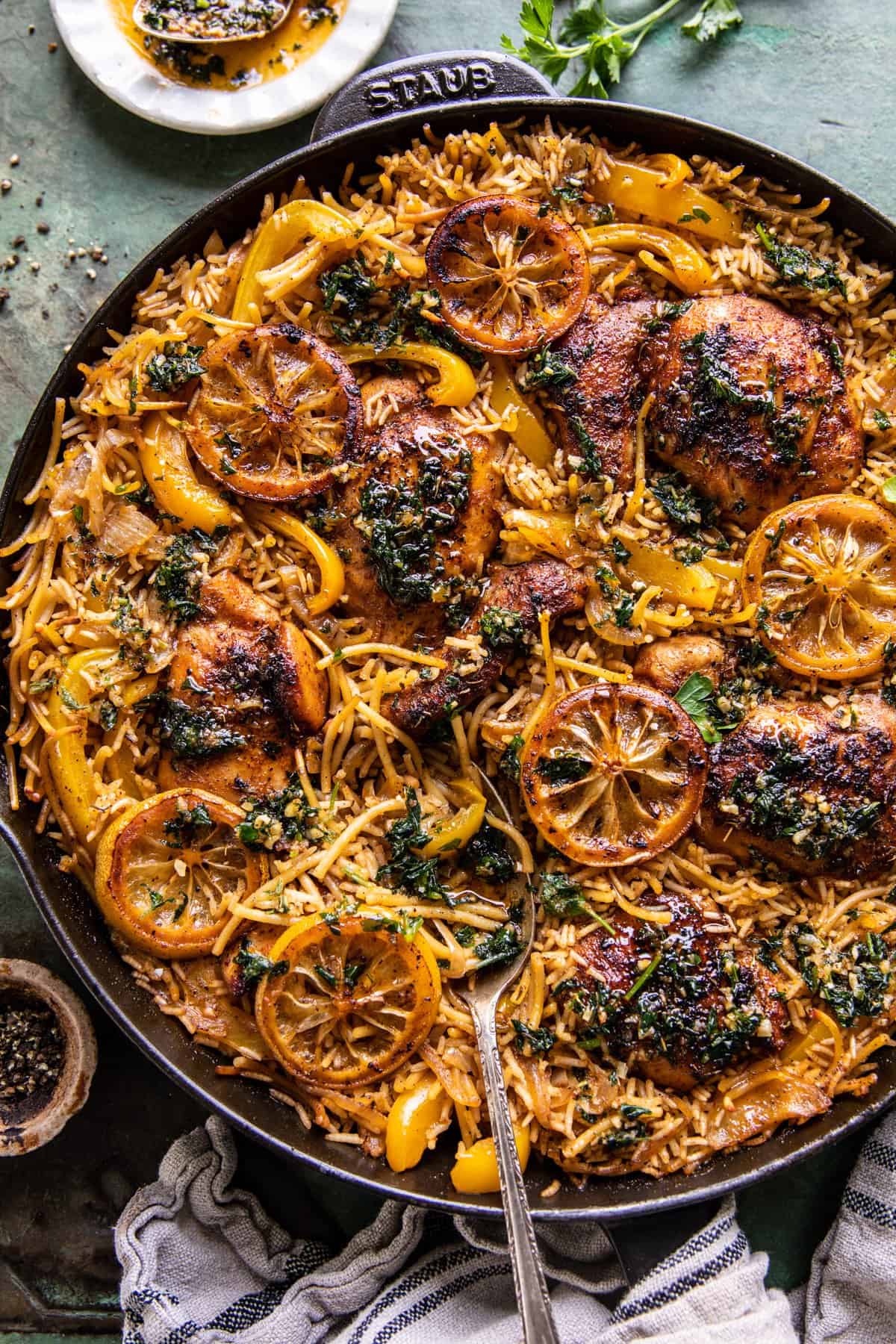 chicken and rice in skillet with herb butter and pepper on table